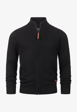 Black knitted zip-up cardigan featuring a high collar, ribbed cuffs, and hem. Includes a brown leather zipper pull and a logo tag.