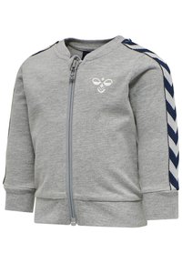 Grå zip-up jacka gjord av mjukt material, med marinblå och vita chevronränder på ärmarna och en liten broderad logotyp på bröstet.