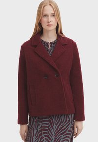 Bordová dvojradová bunda z textúrovanej vlnenej zmesi s vrúbkovaným golierom, dvoma prednými vreckami a čiernymi gombíkmi.