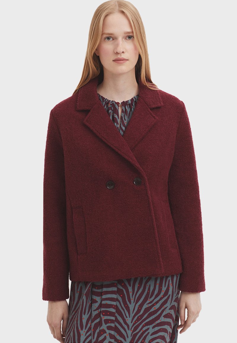 Bordová dvojradová bunda z textúrovanej vlnenej zmesi s vrúbkovaným golierom, dvoma prednými vreckami a čiernymi gombíkmi.