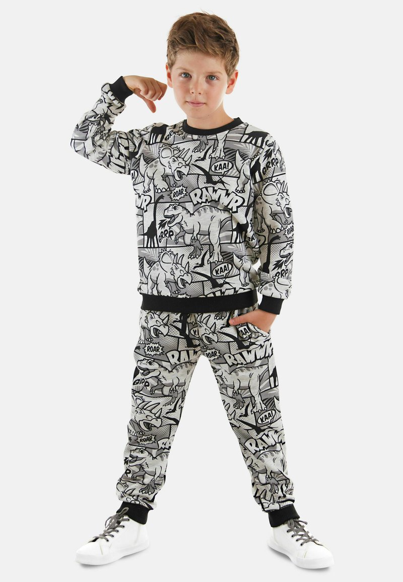 Schwarz-weißer Dinosaurier-Motiv-Sweatshirt und Jogginghose mit elastischen Bündchen, versehen mit Comic-artigen Grafiken und textlichen Akzenten.