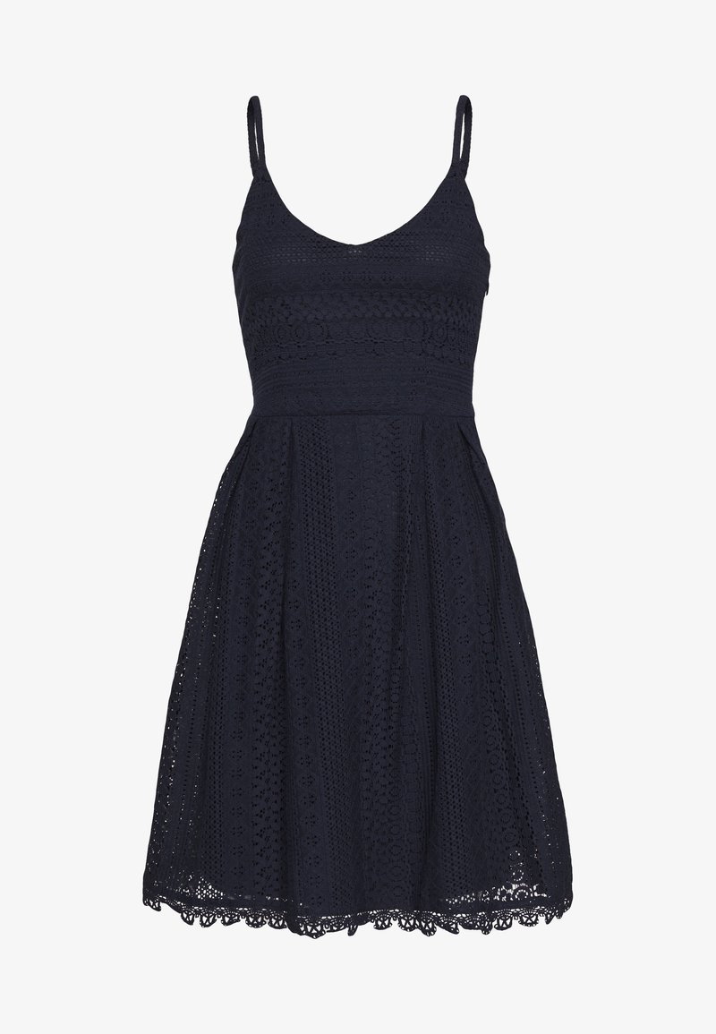 Robe sans manches bleu marine avec fines bretelles et tissu en dentelle à œillets, corsage ajusté et jupe évasée se terminant au-dessus du genou.