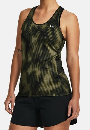 Femme portant un débardeur de sport sans manches camouflage noir et vert olive et un short noir, debout avec les bras détendus le long du corps.