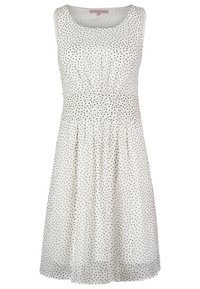 Robe blanche sans manches avec des pois noirs, taille cintrée et décolleté rond, longueur genoux, tissu léger avec des plis subtils sur la jupe.