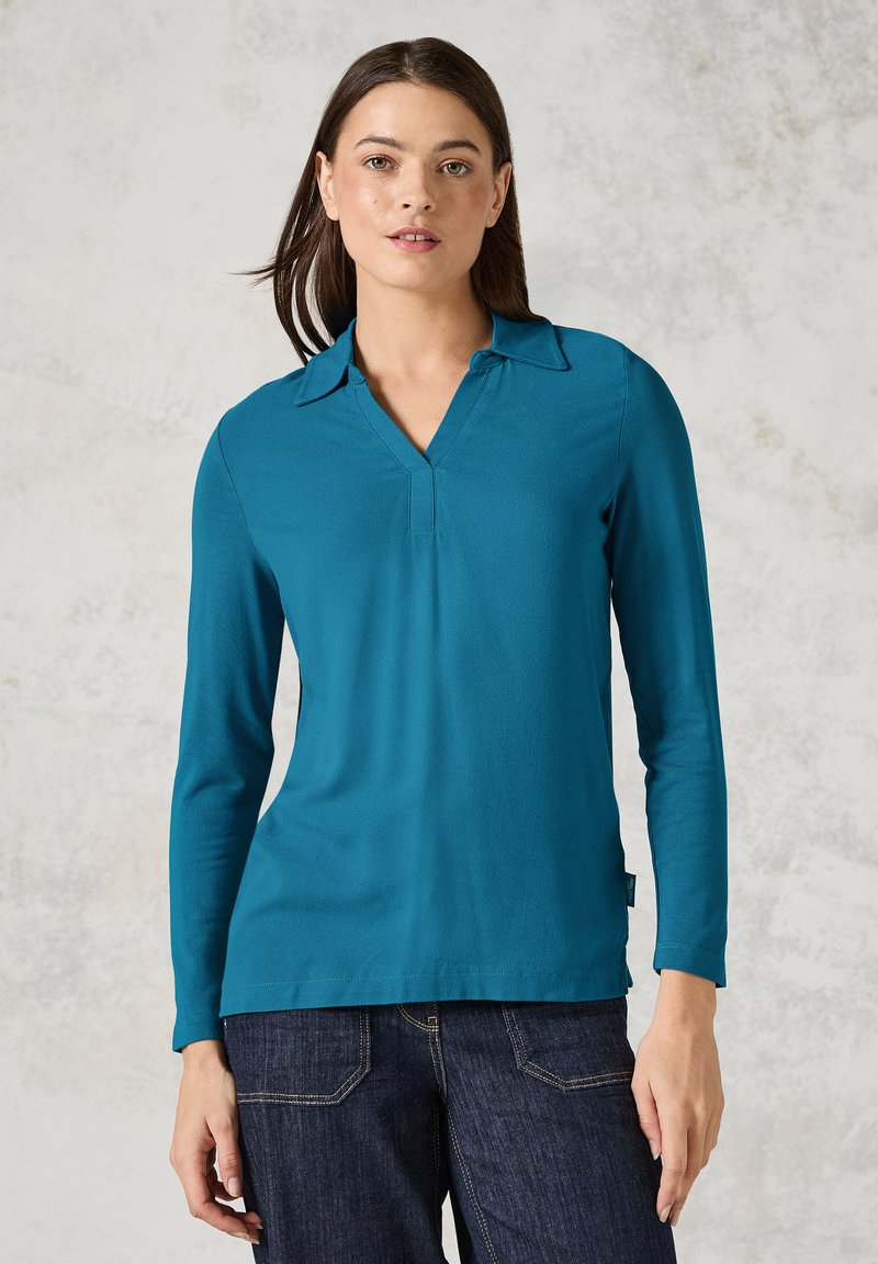 Tiefblaues Langarmshirt mit V-Ausschnitt und Kragen, aus einem glatten Stoff gefertigt. Verfügt über einen geraden Saum und diskrete seitliche Schlitze für Bewegungsfreiheit.