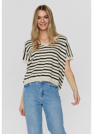 Striped short-sleeve top in beige and black, featuring a V-neck and loose fit, paired with blue high-waisted jeans.