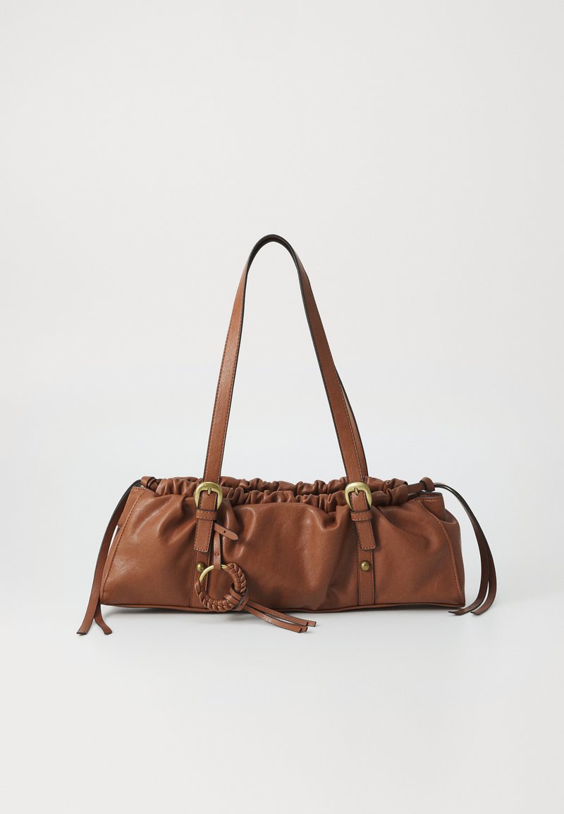 Brown leather handbag with gathered top, adjustable straps, and metal accents. Features a round braided detail on the side.