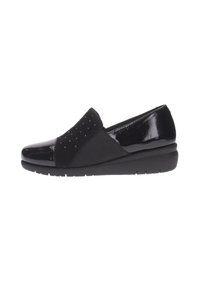 Chaussure noire à enfiler avec un embout en vernis brillant, un dessus texturé à pois et une semelle compensée basse pour le confort.