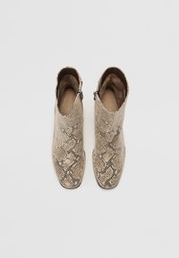 Beige ankle boots featuring a snakeskin texture, pointed toe, and zip closure on the side. Smooth interior lining. Flat sole.