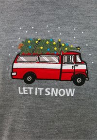 Furgone vintage rosso e bianco ricamato con un albero di Natale e decorazioni sopra, su sfondo grigio, con testo bianco "CHE NEVICHI."