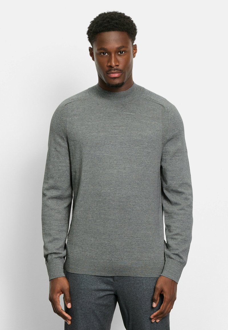 Grauer Strickpullover mit hohem, geripptem Kragen. Lange Ärmel und enger Saum. Weicher Stoff mit subtilen Farbvariationen.