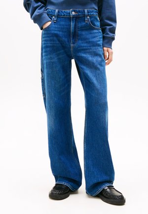 Wide-leg blue jeans made of denim, featuring a high waist, five-pocket design, and visible stitching details. Paired with black loafers.