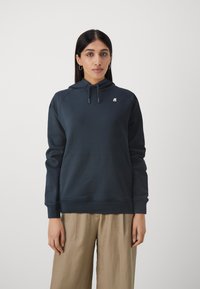 Felpa con cappuccio di un profondo blu navy, realizzata in materiale morbido, dotata di una tasca frontale a marsupio e cappuccio regolabile con coulisse, e un piccolo logo sul petto.