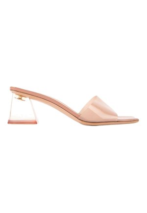 Mule sandale nude à bout ouvert avec un talon bas transparent évasé et une large bride sur le pied.