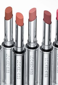 Sechs Lippenstifte in silbernen Kappen. Die Farben reichen von Nude bis Pink. Texturierte matte Oberfläche. "LOCKED KISS" ist in jede Tube eingeprägt.