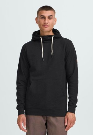Black hooded sweatshirt made of soft fabric, features a front pocket, drawstrings, and ribbed cuffs. Plain design, no patterns or accents.