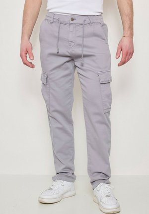 Pantalon cargo gris en coton, doté de poches latérales, d'une taille avec cordon de serrage et d'une coupe ample. Assorti à des baskets blanches.