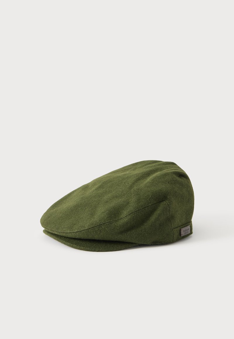 Casquette plate vert olive avec une petite étiquette en tissu sur le côté, présentée sur un fond clair uni.