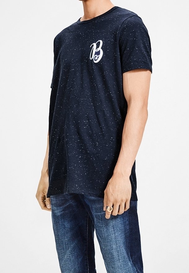 Tmavě modré tričko s tečkovaným vzorem, krátkým rukávem a bílým vyšitým 'B' na levé hrudi. Měkký bavlněný materiál.