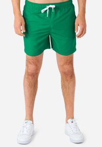 Zelene kupaće gaće izrađene od lagane tkanine s elastičnom linijom u struku i bijelim špagom. Obrezane na bedrima, bez vidljivih uzoraka ili naglasaka.