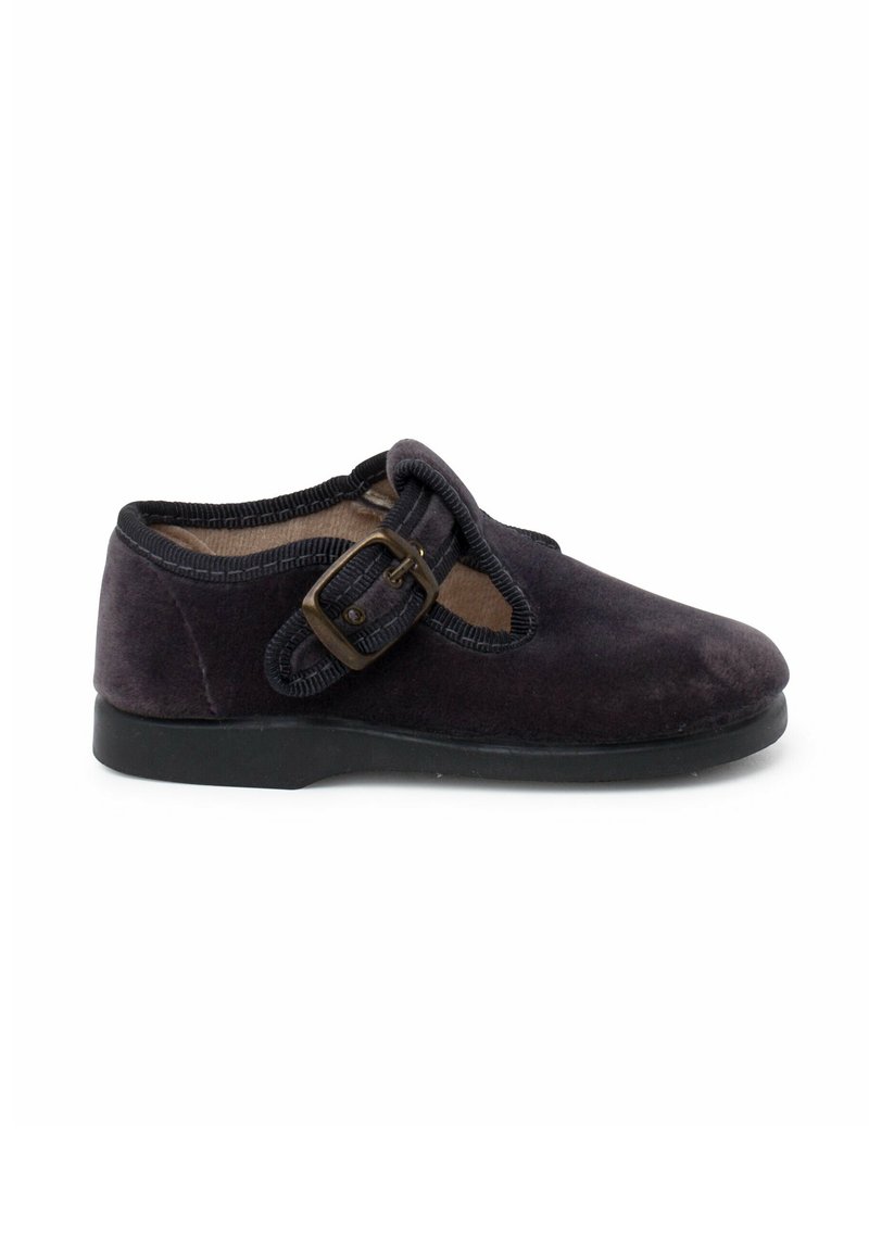 Scarpa in velluto viola scuro con punta rotonda, soletta nera piatta e un evidente dettaglio con fibbia sul lato. I bordi profilati aggiungono texture.