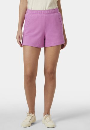 Pantalones cortos morados hechos de una tela suave, con una cinturilla elástica, bolsillos laterales y una textura lisa. Llevados con zapatillas de color claro.