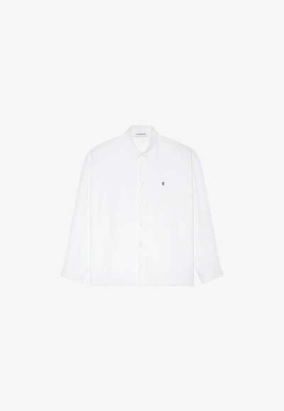Chemise blanche à manches longues en coton, dotée d'une fermeture à boutons sur le devant, d'un col classique et d'un petit logo brodé sur la poitrine.
