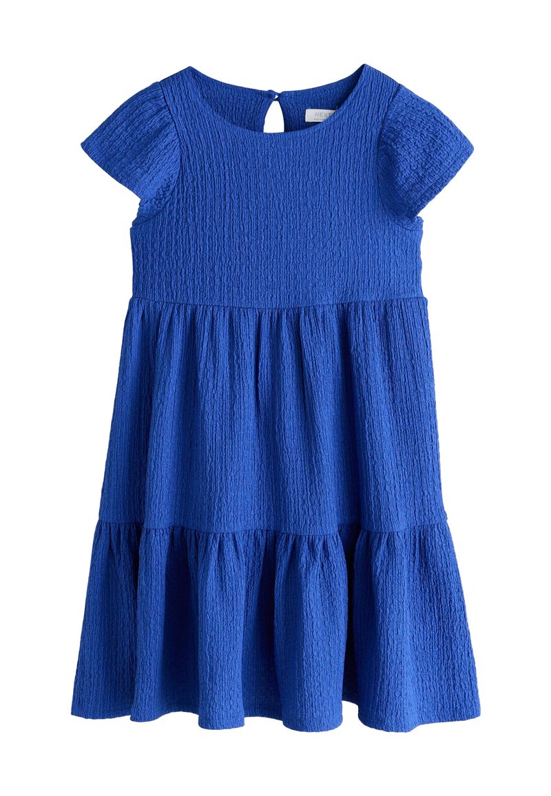 Niebieska sukienka z fakturowanej tkaniny, z krótkimi rękawami, okrągłym dekoltem oraz warstwową spódnicą z tylnym otworem na plecach.