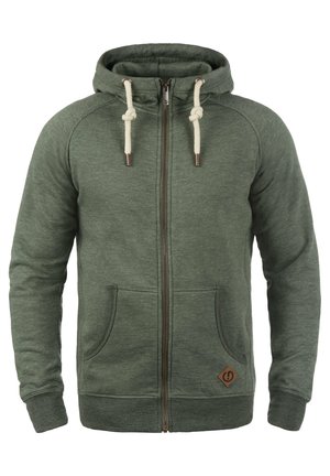 Zelena zip-up dukserica od mekog materijala. Ima vezice i dva prednja džepa. Uključuje mali logo aplikaciju blizu rubu.