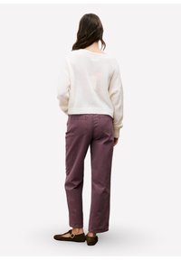 Witte, pluizige sweater met een losse pasvorm; stoffige mauve rechte broek; donkerbruine platte schoenen met sluitingdetails; casual outfit.