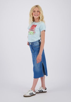 Lyseblå grafisk t-shirt med rød og grøn print, parret med en knælang denimnederdel med en sideslids og frynset kant, båret med hvide sneakers.