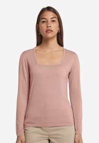 Långärmad tröja i mjuk rosa, med fyrkantig ringning och ribbade ärmslut. Tillverkad av lättviktigt tyg med en slät yta.