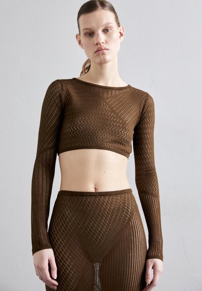 Hnědý pletený crop top s dlouhými rukávy, s geometrickým vzorem a přiléhavým střihem. V kombinaci s odpovídajícími vysokými kalhotami.