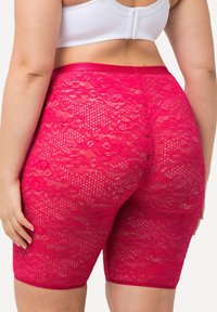 Roze kanten shorts met een bloemenpatroon, strakke pasvorm, midden boven de dijen, en een gladde tailleband. Lichtgewicht, semi-doorzichtige textuur.