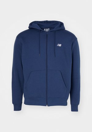 Navy plava zip-jakna izrađena od mekog materijala, s kengur džepom, podesivim kapuljačom i logotipom na prsima.