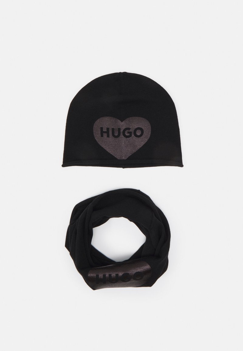 Berretto in maglia nera con una grafica a cuore e "HUGO" in materiale lucido, abbinato a una sciarpa infinita nera con lo stesso logo.