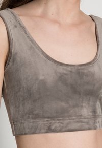 Szary, krótki top bez rękawów wykonany z miękkiego, przypominającego aksamit materiału. Posiada okrągły dekolt oraz szerokie ramiączka o gładkiej fakturze.