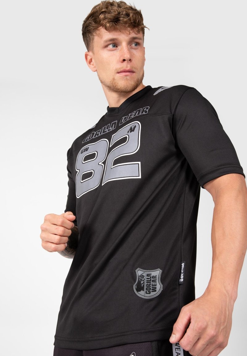 Zwart sportshirt met korte mouwen, met opvallende grijze cijfers (82) en logo. Gemaakt van textuurstof die ademend is.