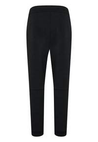 Zwarte joggingsbroek gemaakt van een zachte, rekbare stof. Kenmerkt zich door een elastische tailleband en taps toelopende pijpen met een soepele textuur.