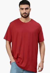 T-shirt in cotone rosso con scollo rotondo, maniche corte e vestibilità comoda, caratterizzata da una texture liscia e un design a taglio standard.