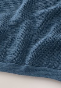 Strukturierte Decke in Dunkelblau, Strickmuster mit einem weichen, gewebten Finish. Verfügt über eine gerippte Kante für zusätzliche Haltbarkeit und Formstabilität.