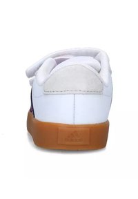 Baskets blanches avec un dessus en cuir lisse, un accent de talon en daim gris et une semelle en caoutchouc coloris gomme. Fermeture à bande Velcro pour un enfilage facile.