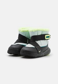 Black and light blue winter boots with a fluffy green lining, strap closure, and textured rubber sole. Nike logo on the side.
