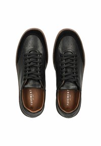 Baskets en cuir noir avec des détails perforés, bout rond et fermeture à lacets. Semelle en caoutchouc brun avec logo embossé sur la semelle intérieure.