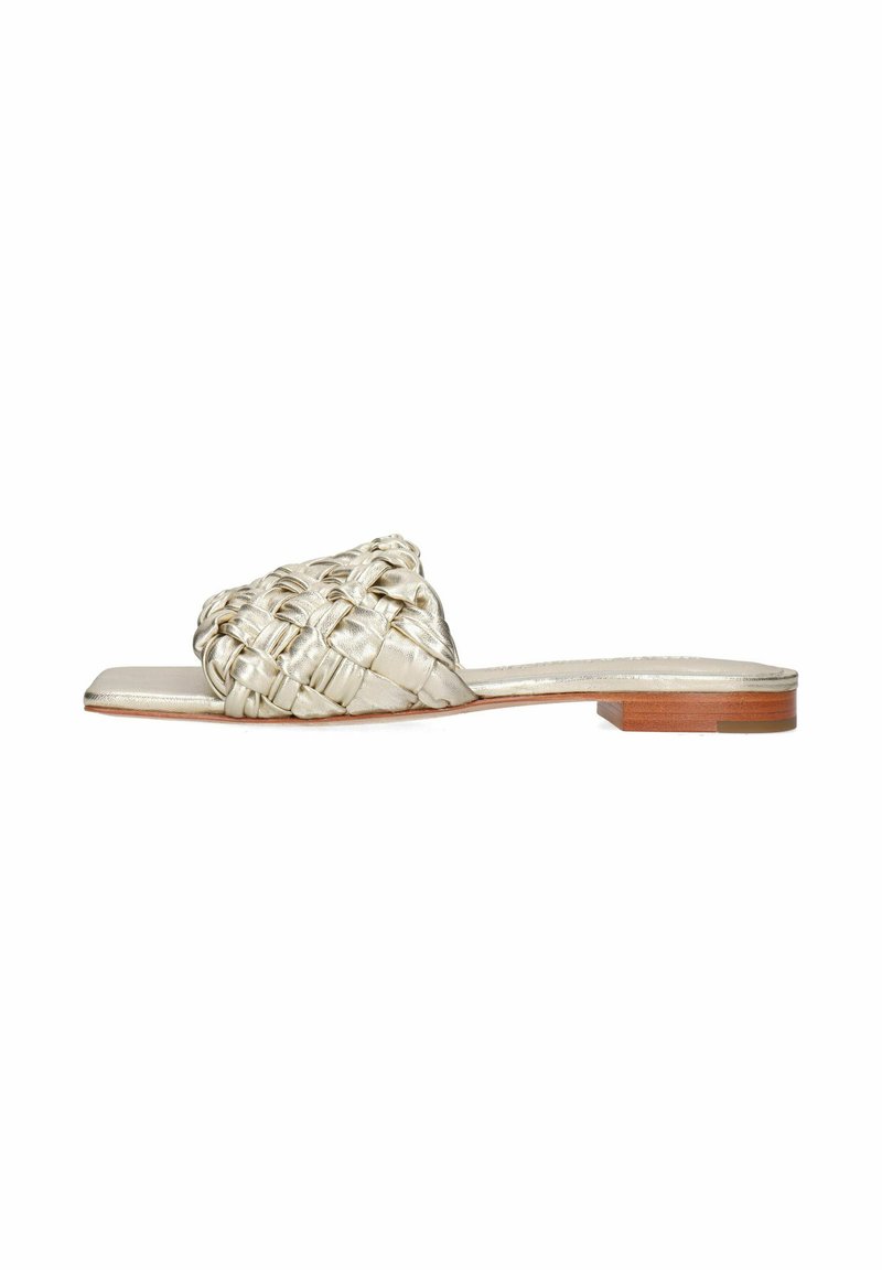 Infradito in metallo dorato intrecciato, con una parte superiore testurizzata, suola piatta e un piccolo tacco in legno, caratterizzati da un design minimalista a treccia.