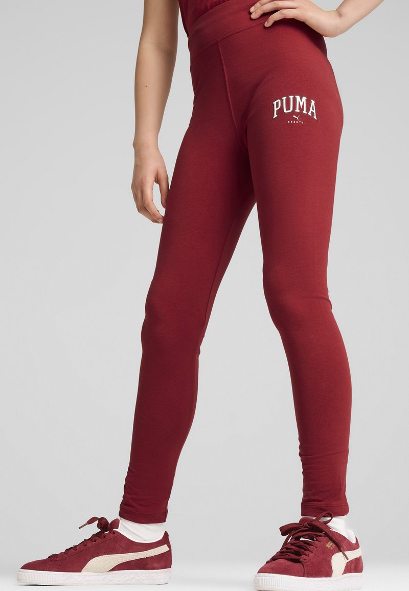 Bordeaux leggings med en bred midja och vit "PUMA"-logotyp på vänstra låret. Slät struktur med en figurnära siluett.
