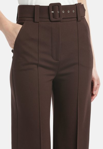 Brūni pielāgoti bikses ar platu kāju, strukturētu audumu, jostu cilpām un saskaņotu jostu ar kvadrātveida sprādzi. Iekļautas sānu kabatas.