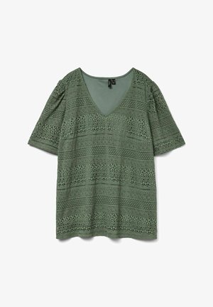 Roheline lühikeste varrukate ja V-kaelusega pluus, millel on keerukad pitsimustrid, mis katavad kogu kanga, asetatuna valgele taustale.