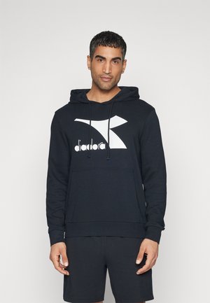 Felpa nera con cappuccio e logo Diadora bianco. Presenta una tasca a kangaroo e polsini a costine; realizzata in un tessuto morbido e testurizzato.