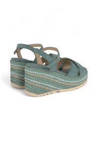 Turkwijfje wedge sandalen met een zachte suede bovenkant, peep-toe ontwerp en een gevlochten jute platform, voorzien van decoratieve kraalaccenten.